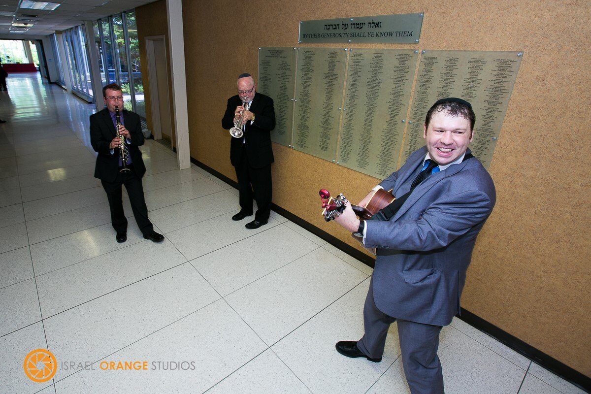 With band members &mdash; sax and trumpet, in front of donor wall